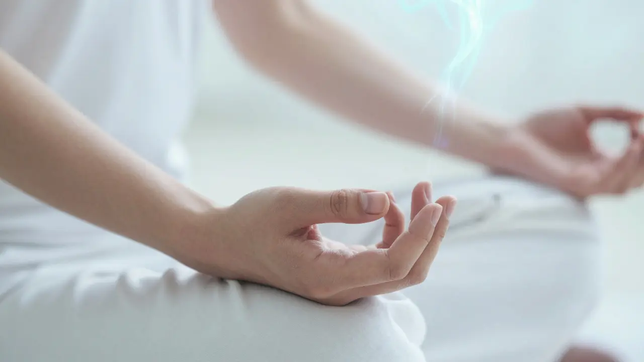 Close-up of hands massaging He Gu acupressure point during meditation